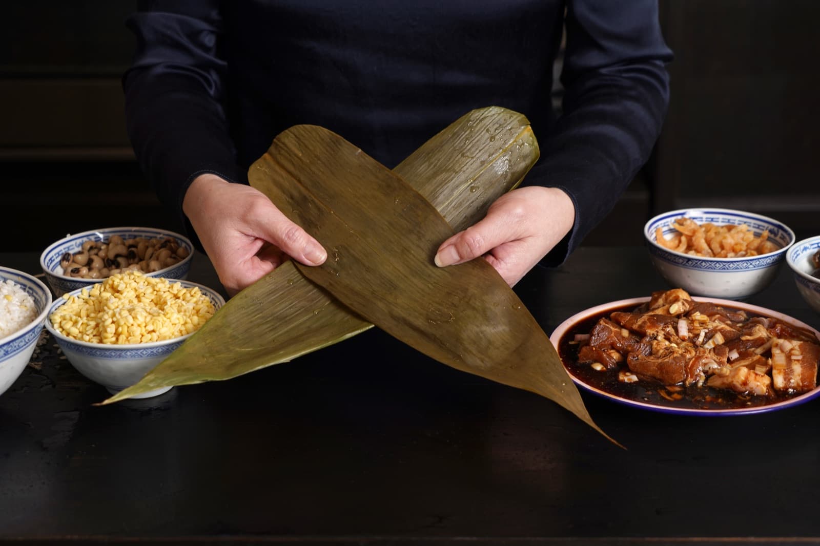 Het vouwen van zongzi in bananenblad - traditioneel Hakka recept